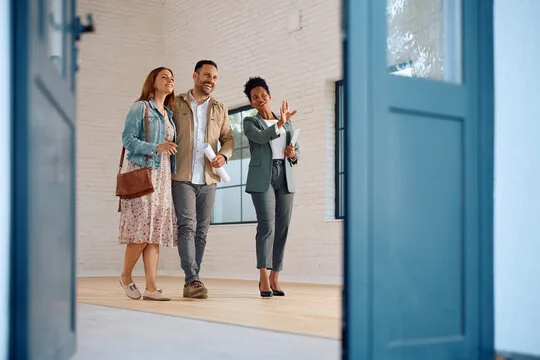 An advisor walking clients through a bright home